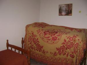 a bed in a room with a blanket on it at Apartamento Temporada Enseada in Guarujá