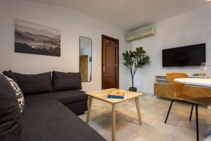 una sala de estar con un sofá y una mesa en Casa Palacio Luna, en El Puerto de Santa María