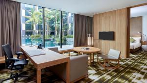a hotel room with a desk and chairs and a bed at Crowne Plaza Changi Airport by IHG in Singapore