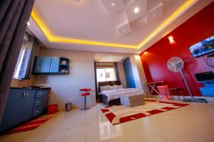 a living room with a bed and red walls at Luxury Studio Apartment in Kampala