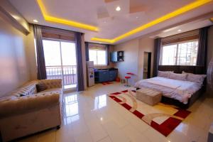 a large bedroom with a bed and a couch at Luxury Studio Apartment in Kampala