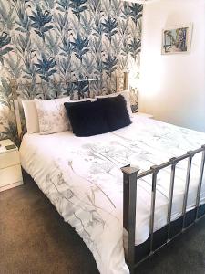 a bedroom with a bed with a tropical wallpaper at Bay Lodge in Penzance