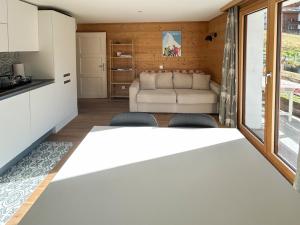 Il dispose d'une cuisine et d'un salon avec une table et des chaises blanches. dans l'établissement Flat with magnificent views of the Matterhorn, à Zermatt 3 autres photos