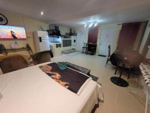 a room with a bed and a living room with a kitchen at Comfort Suites - Studio One in La Fargue