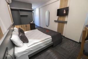 a small room with a bed and a tv at Hotel ABBARA in İzmir