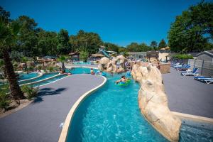 a pool at a theme park with people in the water at Camping Lou Pignada in Messanges
