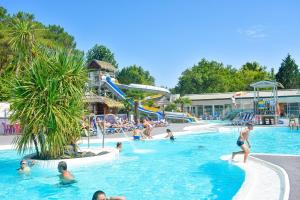 a group of people in a pool at a resort at Camping Lou Pignada in Messanges