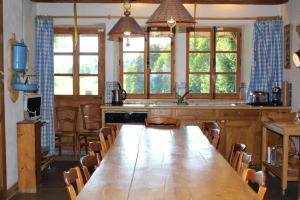 a large kitchen with a long wooden table and chairs at L'Annexe Apparthôtel du Haut-Doubs, 4 étoiles in Les Hôpitaux-Vieux