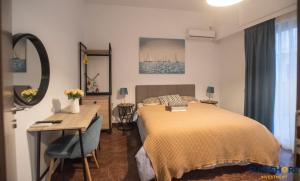 a bedroom with a bed and a table and a desk at Explore Greece from Lovely City Centre Apartment in Chalkida