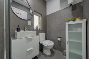 une salle de bain avec toilettes, lavabo et miroir dans l'établissement Cosy Penthouse in Hamrun - Walking distance to Valletta, à Hamrun