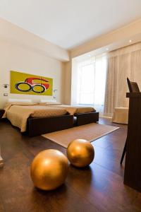 a bedroom with a bed and two gold spheres on the floor at Cinquecento B&B in Barcellona-Pozzo di Gotto