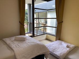 a bedroom with a bed and a large window at Family Only Cozy Villa on Top of Bandung - De Reiz Iris Syariah 4BR in Ciburial