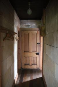 an empty hallway with a wooden door in a building at Granny Grunkes Cottage in Oamaru