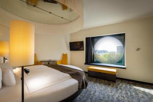 a hotel room with a bed and a window at ARCOTEL Onyx Hamburg in Hamburg