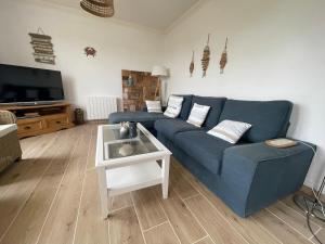 a living room with a blue couch and a table at Penvenan house in Penvénan