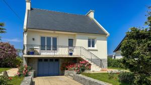 a white house with a blue garage at Penvenan house in Penvénan