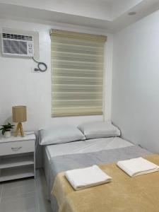 マンダウエ・シティにあるBubees Place Cebu Staycationの窓とテーブル付きの部屋のベッド2台