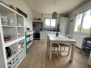 a kitchen with a white table and a table and chairs at Penvenan house in Penvénan