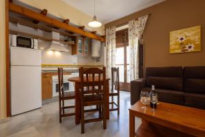 Una cocina y una sala de estar con un sofá y una mesa. en Casa Palacio Luna, en El Puerto de Santa María