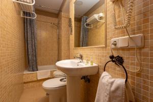 Un baño con lavabo, inodoro y espejo. en Casa Palacio Luna, en El Puerto de Santa María 37 fotos más