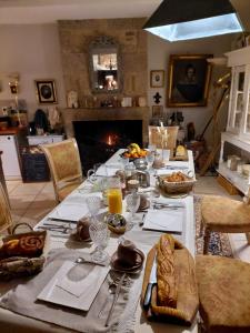 a table set with food and drinks and a fireplace at Manoir de la Chapelle in Alençon