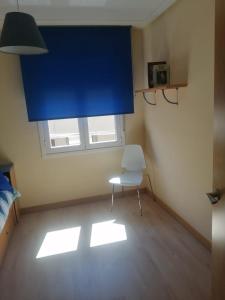 a room with a chair and a blue window at El piso de Amalia in Casalarreina +13 photos