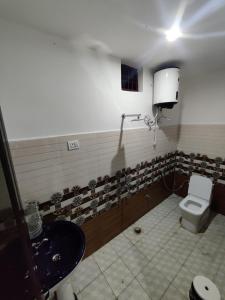 a bathroom with a toilet and a sink at Shiv Mahima Hotel in Sonprayag
