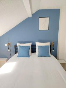 a bed with blue walls and two blue pillows at Cosy 2 - Audincourt centre in Audincourt