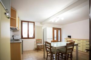 a kitchen and dining room with a table and chairs at Dimora Alba di Mare in Pellestrina