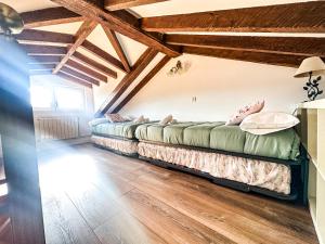 two beds in a room with wooden ceilings at casa rural cobreces in Cóbreces