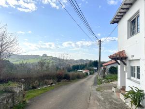 an empty road next to a white house at casa rural cobreces in Cóbreces