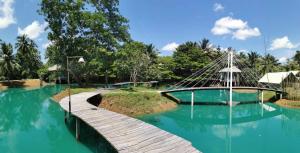 un ponte girevole su una piscina di acqua blu di Farmsuk Residence and Resort a Langu