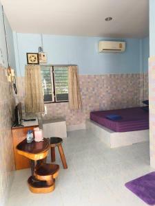 a bedroom with a bed and a table and chairs at Wanna House in Prachuap Khiri Khan