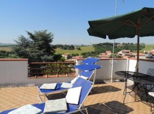 a group of chairs and an umbrella and a table at Villetta Elena Via Loreto 64 villa 14 in Marcelli
