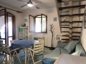 a living room with a table and a couch and stairs at Villetta Elena Via Loreto 64 villa 14 in Marcelli