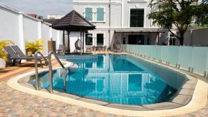 ein Swimmingpool mit blauem Wasser vor einem Haus in der Unterkunft Urbanite Hotel in Vientiane