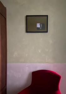 a room with a red chair and a mirror on a wall at Casa Etra in Torre di Palme +6 photos