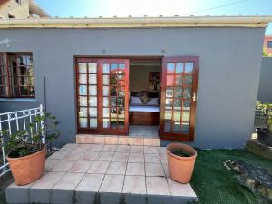 a porch of a house with doors and plants at Zensa Hotel & Spa in East London