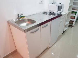 a kitchen with a sink and a microwave at Bas de maison envoutant in Port-Saint-Louis-du-Rhône
