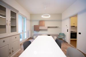 une salle à manger avec une grande table blanche et des chaises dans l'établissement La Casa del Lago, à Manerba del Garda