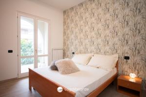 - une chambre avec un lit orné d'une fresque murale dans l'établissement La Casa del Lago, à Manerba del Garda