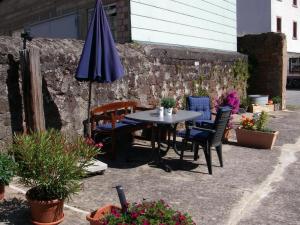 a patio with a table and chairs and an umbrella at Ferienwohnungen Thul in Schweich