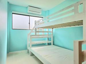 Camera con letto a castello, scala e finestra. di Petit villa Sea grapes a Nago