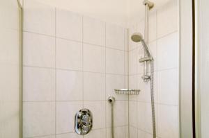 a shower with a shower head in a bathroom at Strandhus Uiterst-hörn Luv in Baltrum