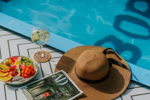 a hat and a bowl of fruit next to a swimming pool at Minimalist Panjim in Panaji +63 photos