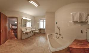 un ampio bagno con vasca, 2 lavandini e vasca di Hotel Hirschen a Sankt Peter