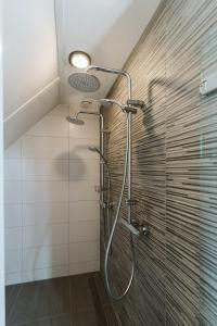 Un baño con ducha con puerta de cristal en Vakantiehuis 6 persoons luxe, en Ouddorp