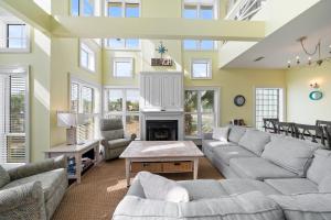 a living room with couches and a fireplace at Calypso Breeze in Gulf Shores