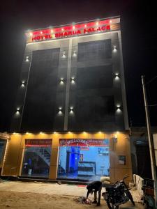 Una motocicleta estacionada frente a una tienda por la noche en Hotel Sharda Palace, en Vrindāvan
