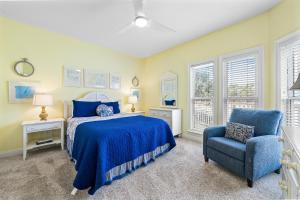 a bedroom with a bed and a blue chair at Calypso Breeze in Gulf Shores